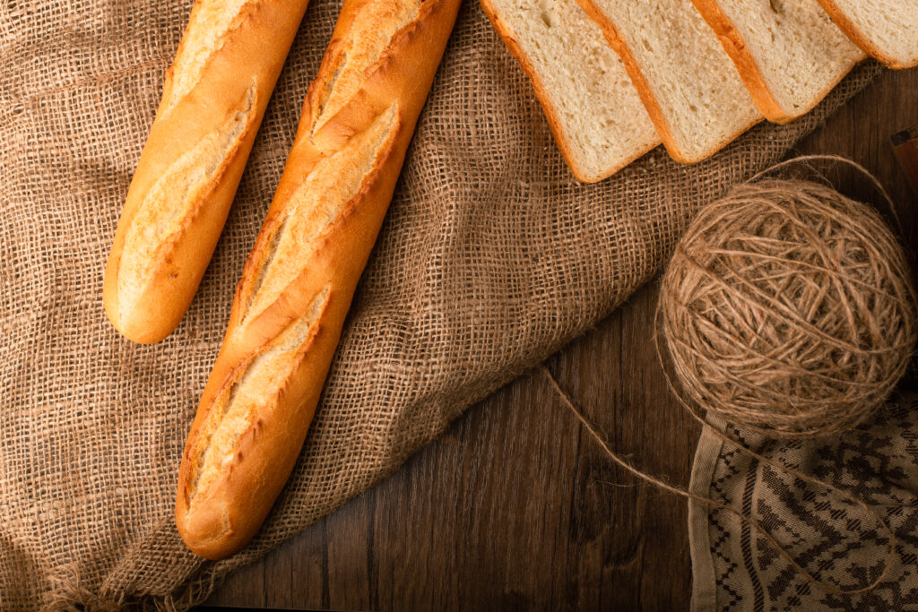 tasty baguette with slices white bread