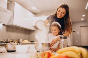 mother with daughter baking kitchen together