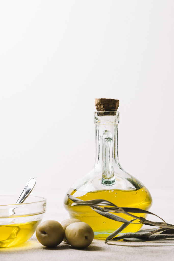 vertical shot olive oil bottle with olives