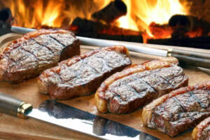 cortes para churrasco sendo levados para o fogo