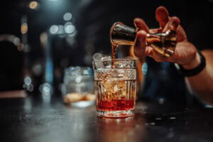 mão servindo dose para drinks com whisky