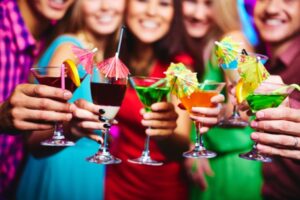 Grupo de amigas segurando drinks coloridos.