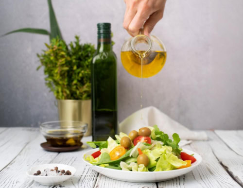 Azeite sendo despejado na salada.