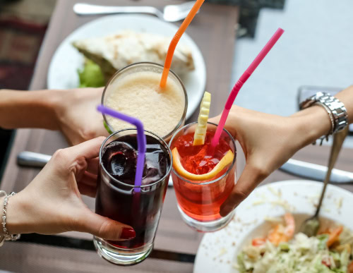 Três copos de bebida se unindo em brinde. 