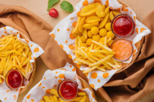 Pratos com batatas fritas e molhos.