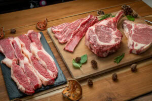 Diferentes cortes de carne sobre tábua de madeira.