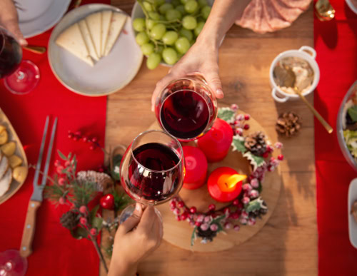 Duas taças de vinho em brinde na mesa de Natal.