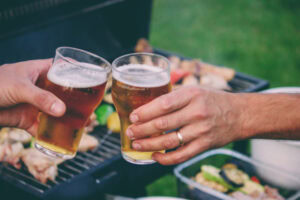 Aprenda como calcular bebida para churrasco | Blog Prezunic Três amigos brindando em churrasco.